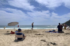 Beach goers enjoy a sunny day on the white sands of Porthcurno beach, Porthcurno, Cornwall, England. (Photograph by Kim Newton)