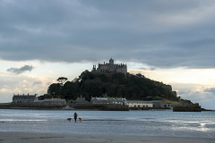 A woman walks her two dogs in front of Saint Michael's Mount a tidal island in Mount's Bay, Marazon, Cornwall, England. Access to the public is by boat or walking across a cobbled causeway during low tide. (Photograph by Kim Newton)