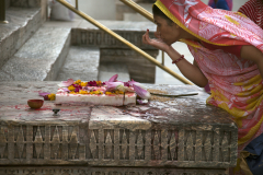 A Hindu woman marks her forhead with a Tilaka or tika in Hindi at the Jagdis Temple in Udaipur, Rajistan, India.
