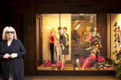 A woman stands in front of her clothing store in Orvieto, Italy.
