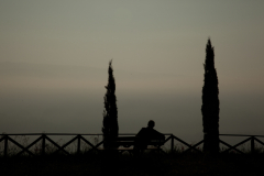 A man watches the sunrise from the gardens of Saint Patricks Well in Orvieto, Italy