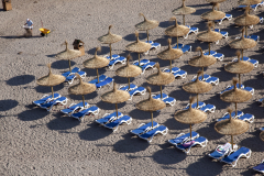 A hotel worker sifts though sand on the beach in Saint Elm, Mallorca, Spain.