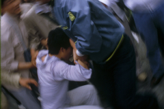 A South Korean plainclothes policeman, right, tries to arrest a pro-democracy protestor during anti-government demonstrations in Seoul, South Korea. The protesters called for reforms to the democratic process. (Photograph by Kim Newton)