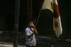 A protestor holds the flag of the Republic of South Korea during pro-democracy protests in the Myeong-dong district of Seoul, South Korea.   The protests in the 1980s led to direct democratic elections, the release of political prisoners and the right of dissidents to participation the political process.