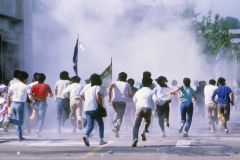 Yonsei University students flee a barrage of tear-gas attacks from government riot police, during pro-democracy protests in Seoul, South Korea. The students were demanding constitutional electoral reform and the release of political prisoners. (Photograph by Kim Newton)