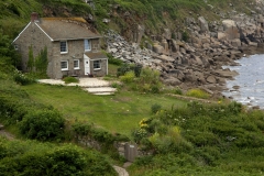 A stone house on the coast at the end of the bay in Lamorna Cove, Cornwell, England.