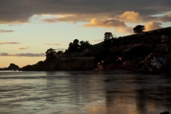The sunsets over the the mouth of the Russian River as it flows into the Pacific Ocean in Jenner, California.