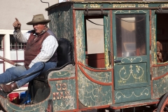 A stage coach driver points during a conversation with tourists in Tombstone, Arizona.